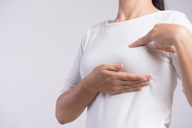 אישה בוחנת תסמינים בחשד להתפתחות של סרטן השד